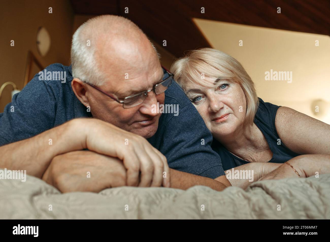 Portrait of a married elderly couple who lies on the bed. Stock Photo