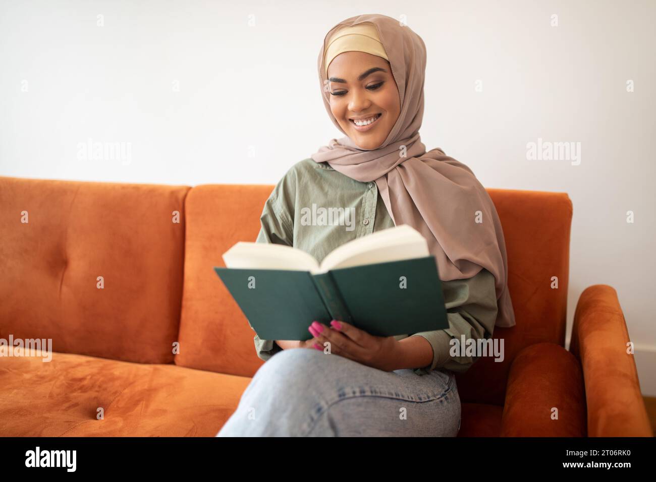 Muslim young woman in hijab relaxing with book at home Stock Photo - Alamy