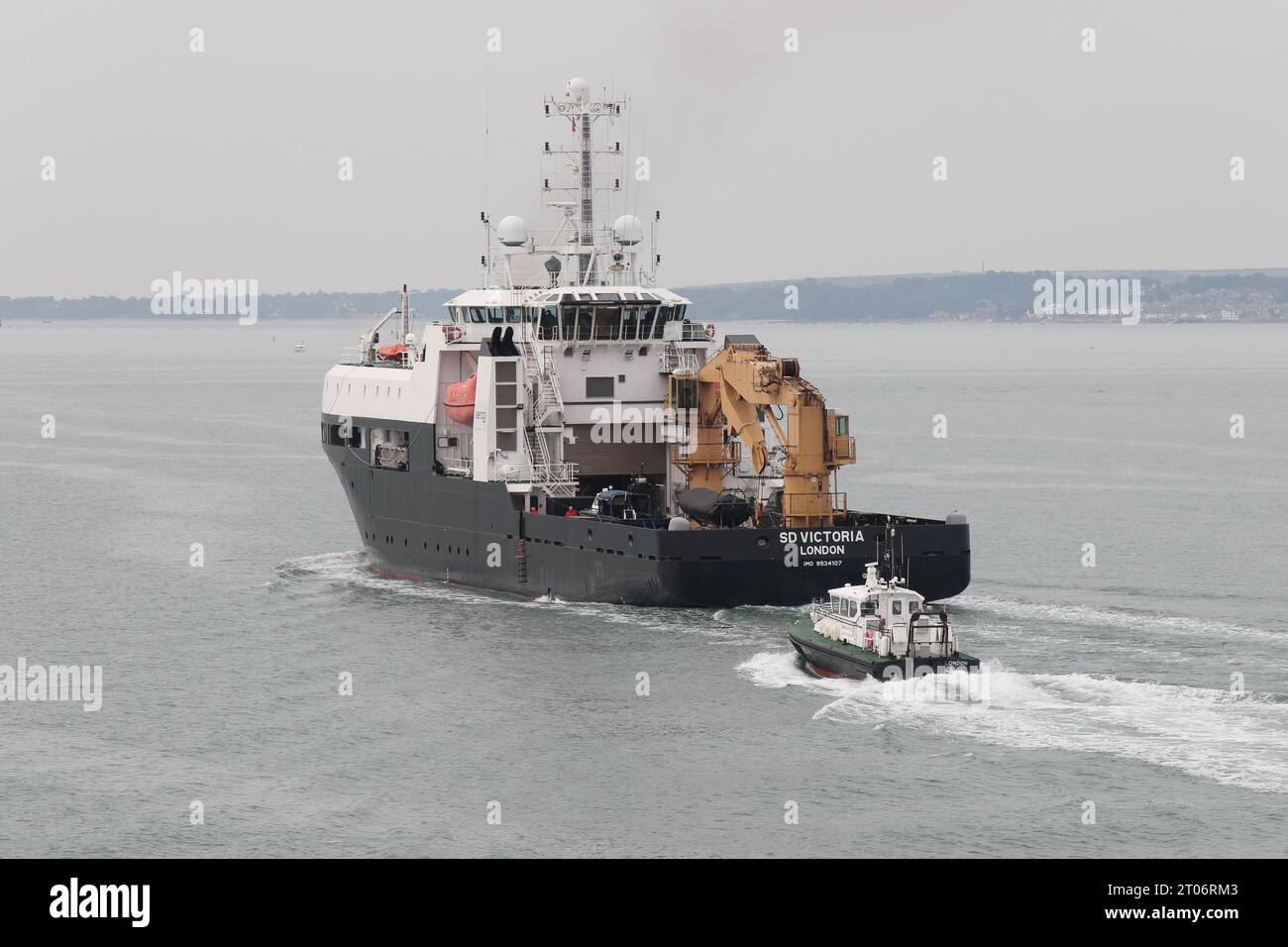 An Admiralty pilot launch sails close to the stern of the Serco Marine Services vessel SD VICTORIA Stock Photo