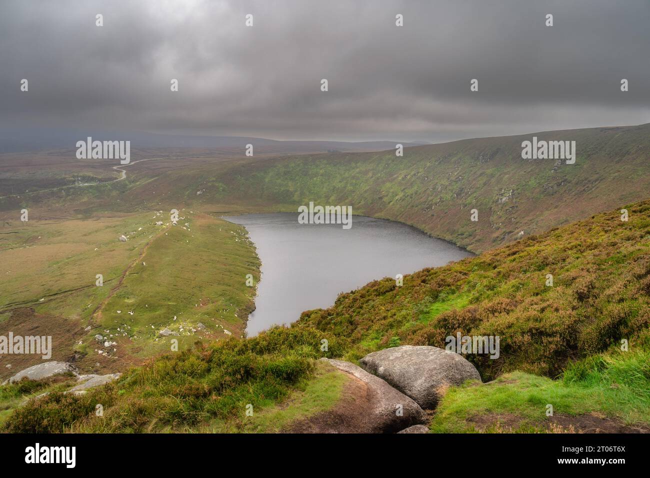 View on the lake Lough Bray from the top of the hill, covered in moody, dramatic storm clouds. Hiking in Wicklow Mountains, Ireland Stock Photo