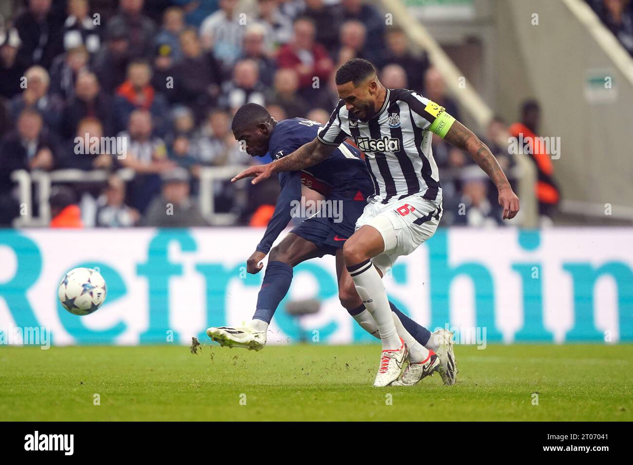 Newcastle United's Jamaal Lascelles challenges Paris Saint-Germain's Ousmane Dembele during the UEFA Champions League Group F match at St. James' Park, Newcastle upon Tyne. Picture date: Wednesday October 4, 2023. Stock Photo