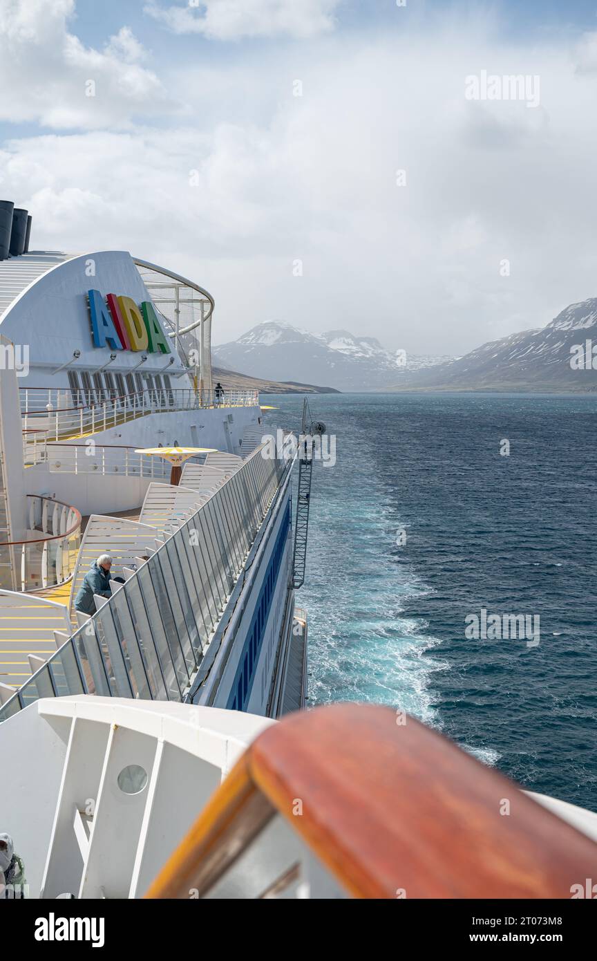 AIDA Bella cruise ship at the Fjord near Seydisfjordur, Iceland during foggy weather, AIDA Logo and boat deck in front, vertical shot Stock Photo