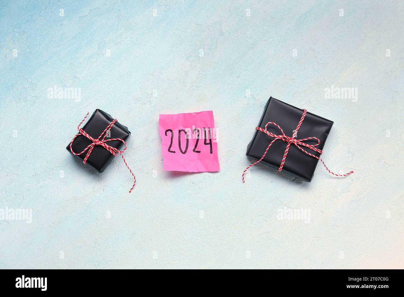 Sticky note with year 2024 and gift boxes on gradient background Stock Photo