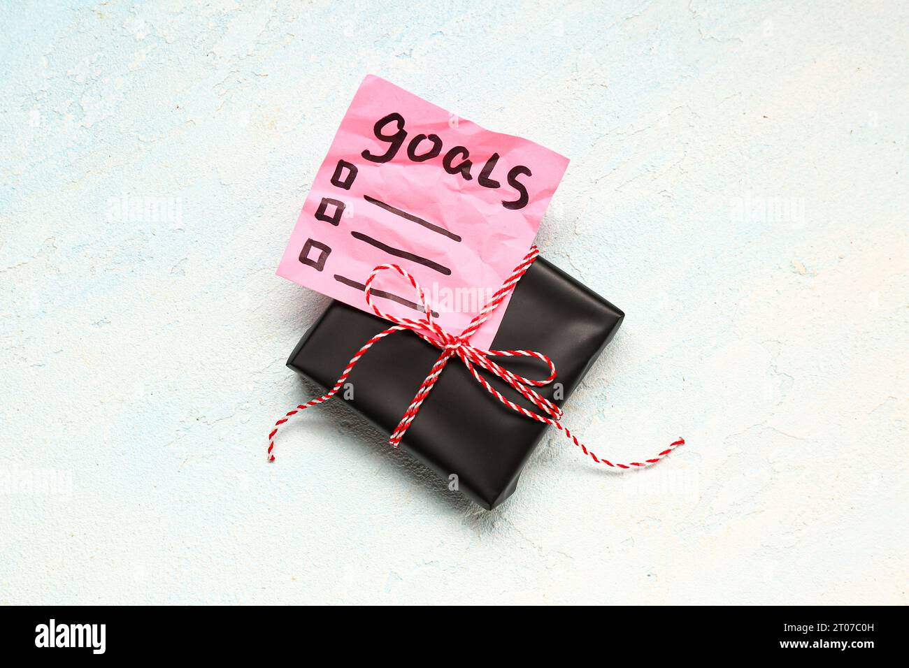 Sticky note with goals for 2024 and gift box on gradient background Stock Photo