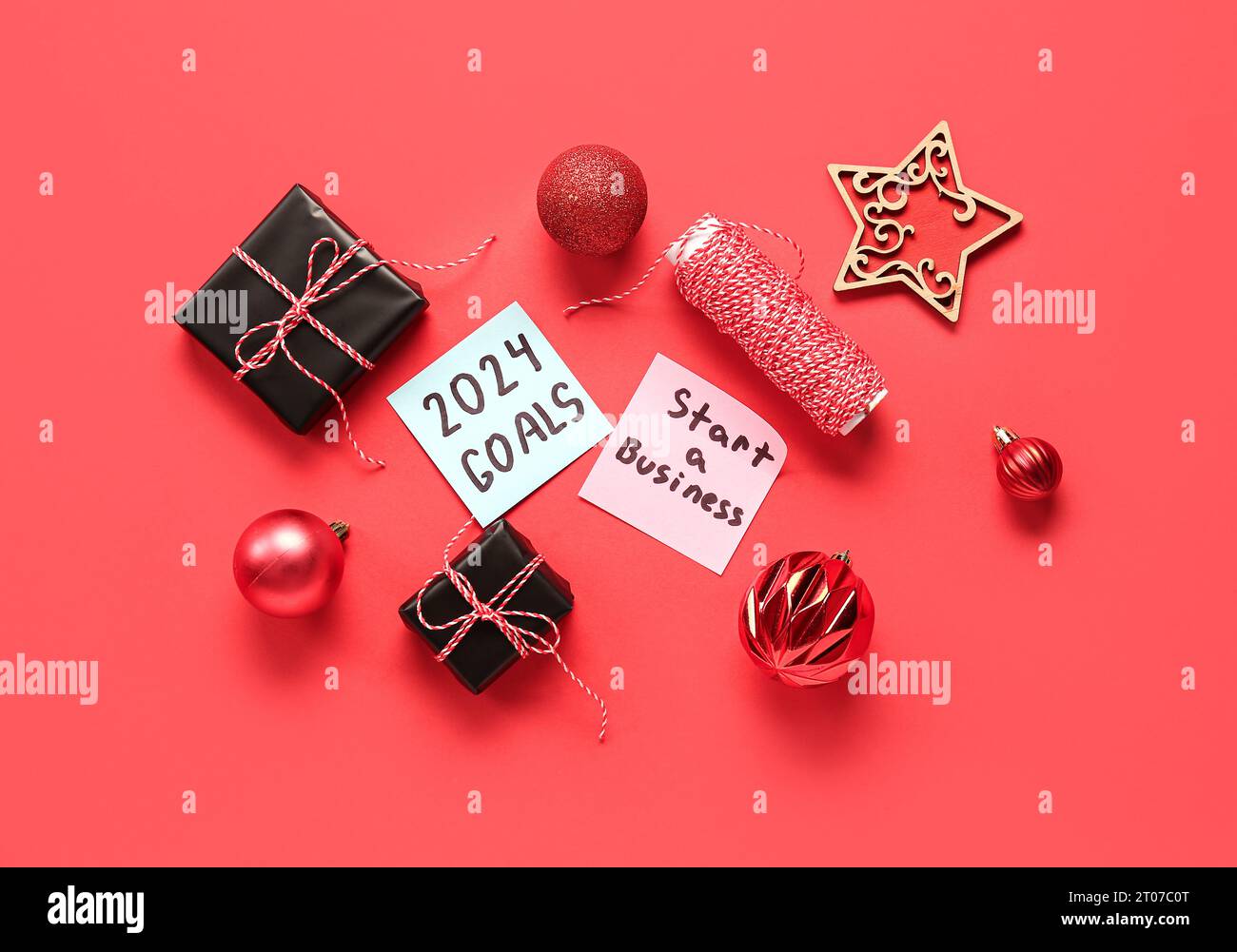 Sticky notes with goals for 2024, gift boxes and Christmas decorations