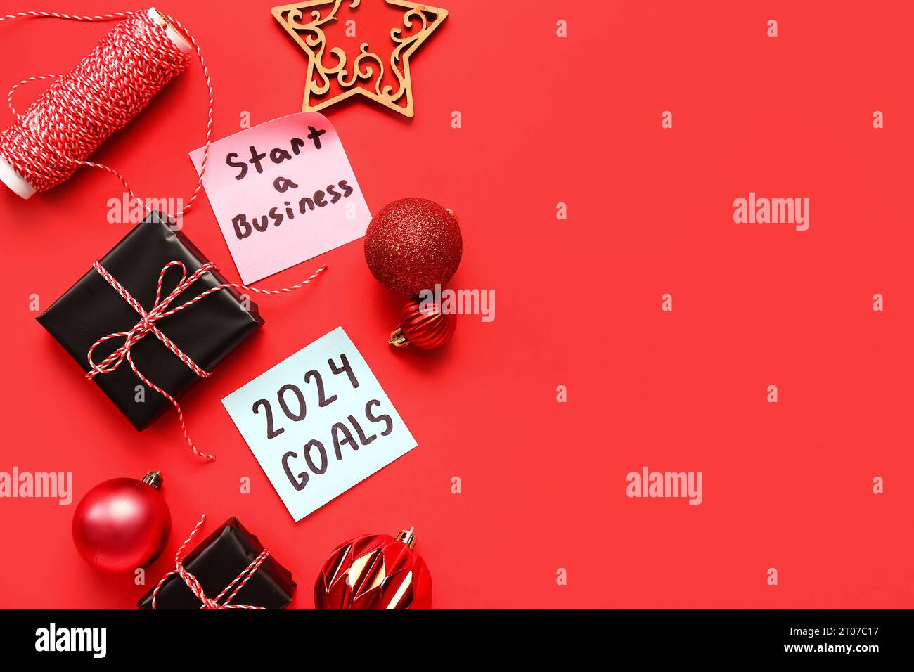 Sticky notes with goals for 2024, gift boxes and Christmas decorations