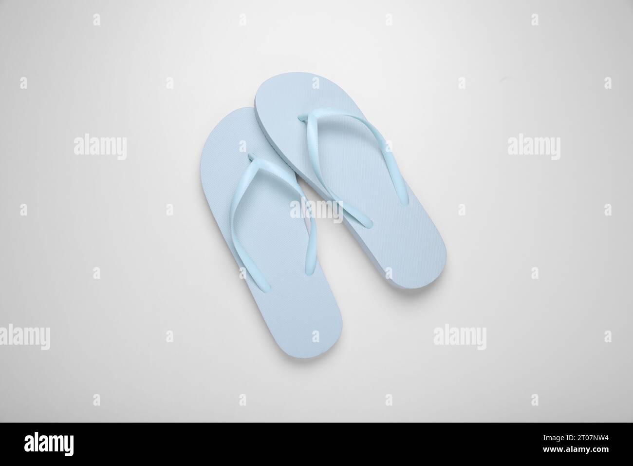 Light blue flip flops on white background, top view Stock Photo - Alamy