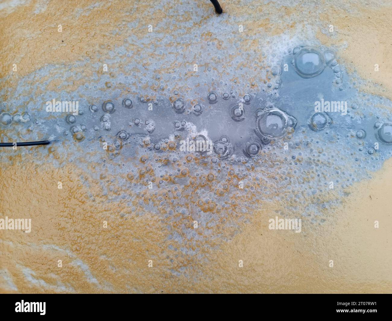 water surface in aquarium with bubbles and rust due to an experiment electrolysis process to