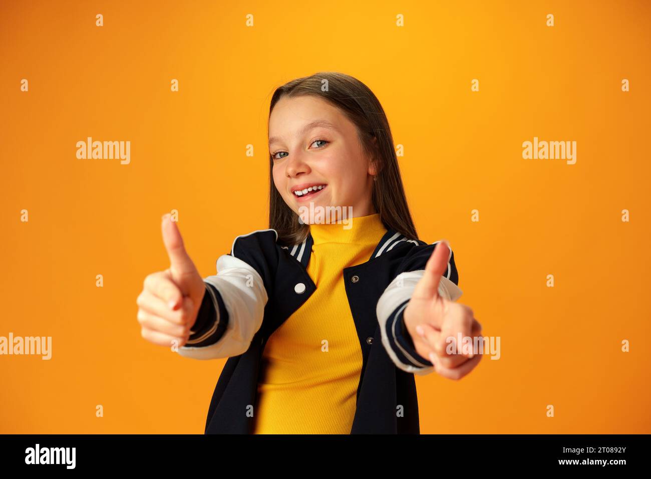 Teen girl showing thumb up sign against yellow background Stock Photo ...