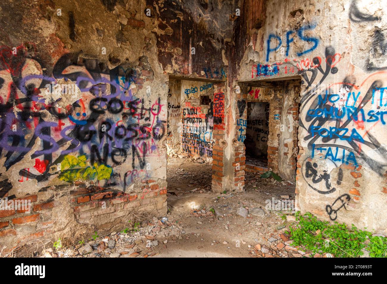 Interno di palazzo disabitato, degradato e vandalizzato con graffiti e scrittre sui muri Stock Photo