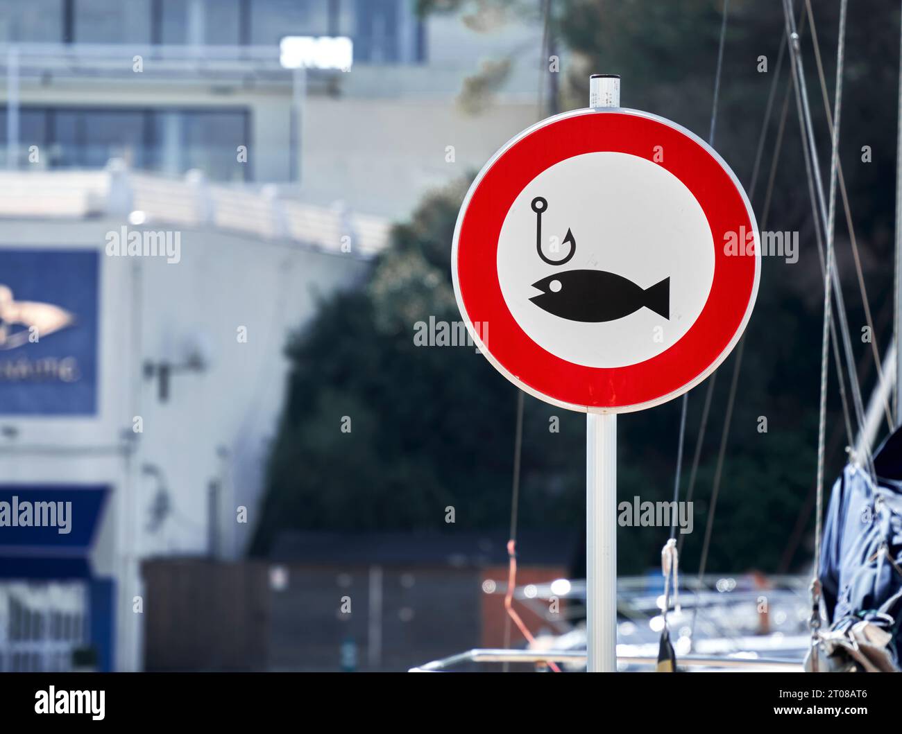 Sign with a fishing hook and a fish in a red circle indicating that fishing is prohibited in the harbor Stock Photo