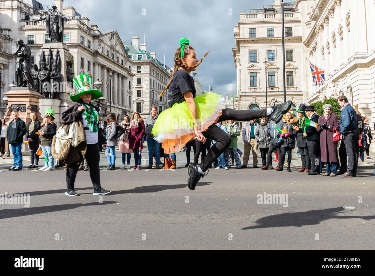 Irish Dancer of Drumenagh School at the 2017 St. Patrick's Day Parade in London, UK. Young female dancer leaping high with audience in street Stock Photo