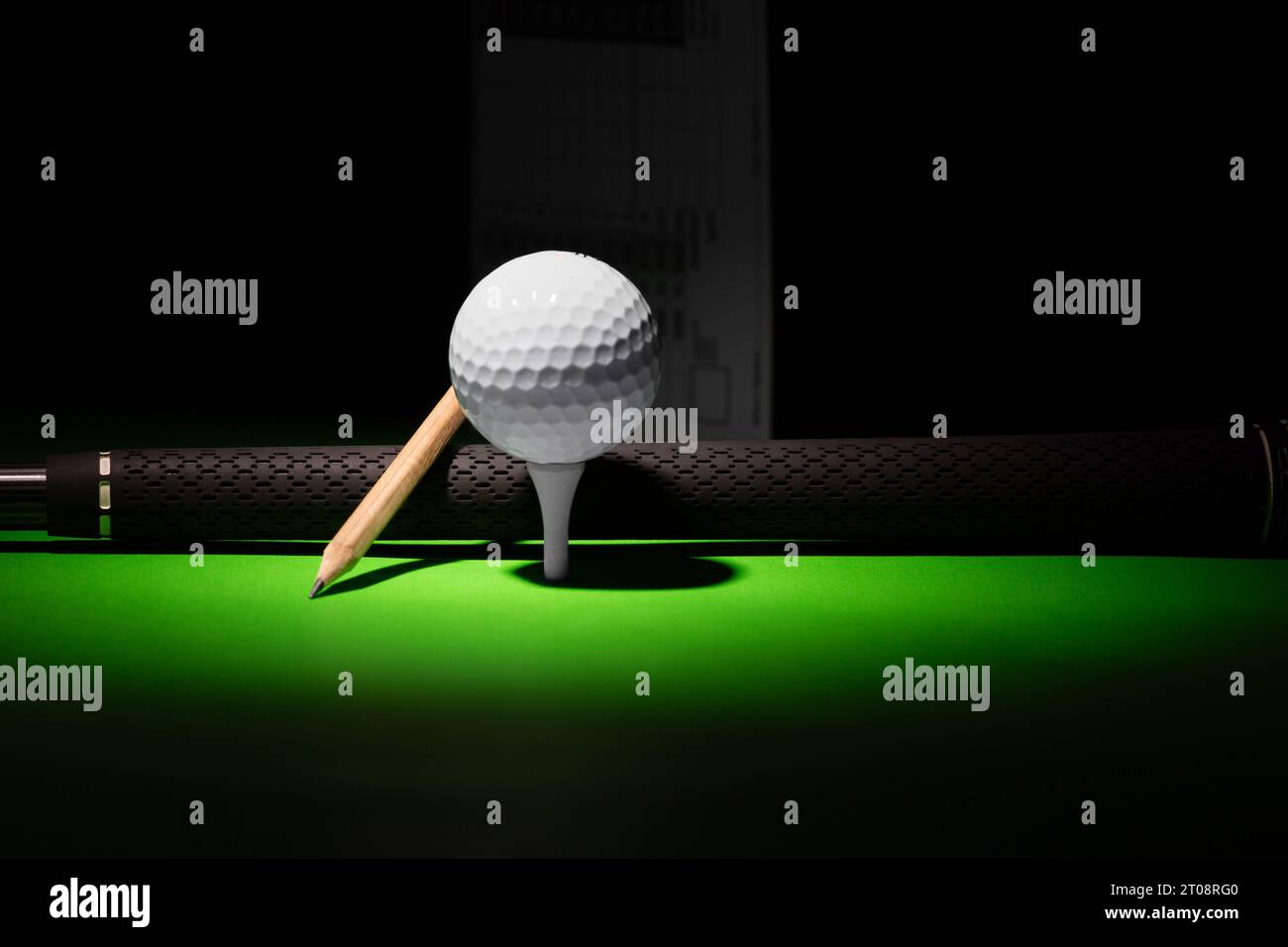 Golf Ball Pencil and Club Handle grip with score card in the distance,  golf equipment on a black and green background Stock Photo