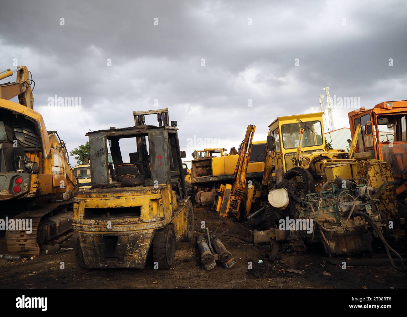 Scrap bulldozer and machinery part at junkyard under dramatic sky