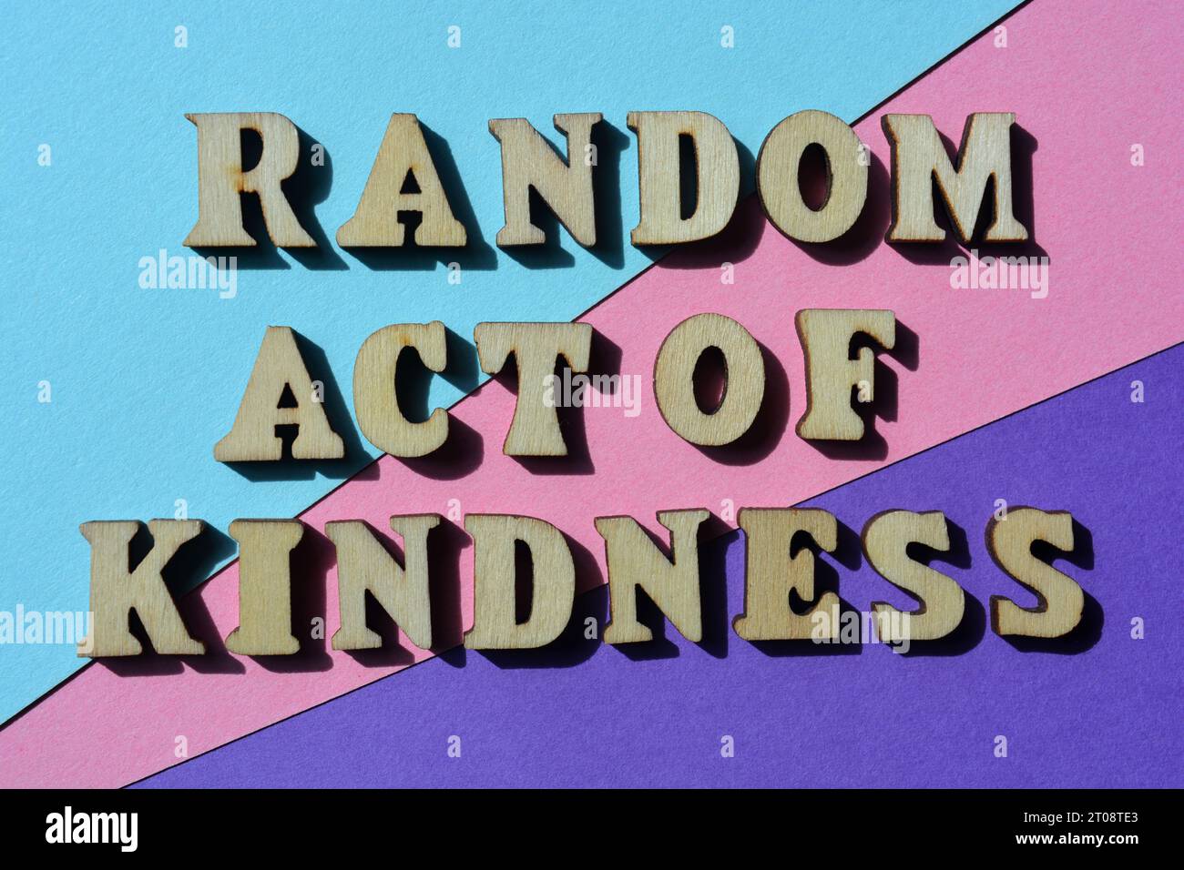Random Act of Kindness, words in wooden alphabet letters isolated on background as banner headline Stock Photo
