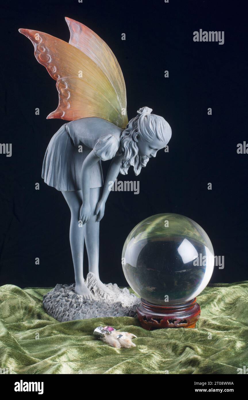 Winged fairy looking into a crystal ball - John Gollop Stock Photo
