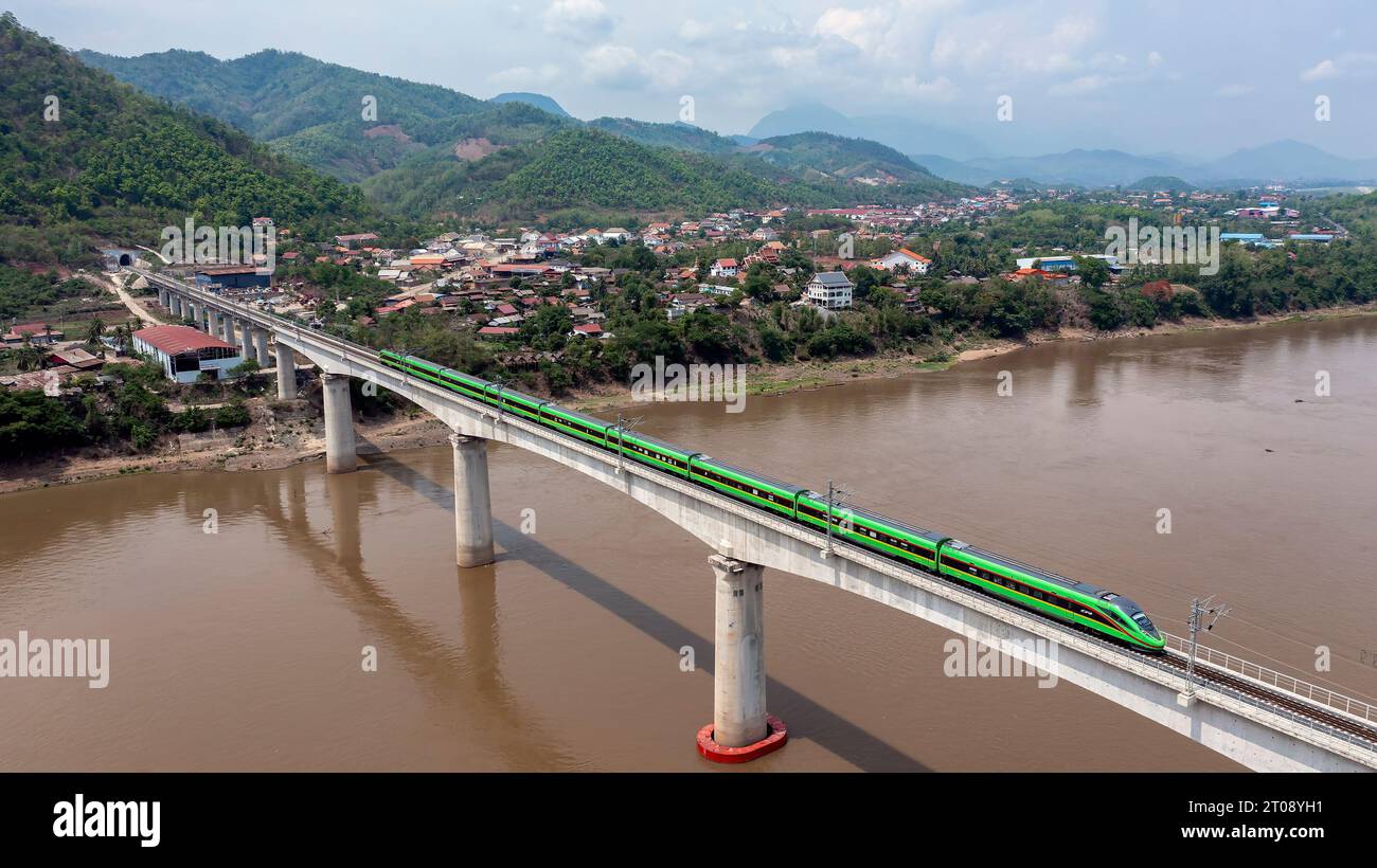 Beijing, China. 28th May, 2023. A train drives on the China-Laos Railway's Luang Prabang cross-Mekong River super major bridge in Laos, May 28, 2023. The bridge, some 230 km north of Lao capital Vientiane, has a total length of 1,458.9 meters and is composed of 28 span T-beams and six spans continuous beams. It is the most difficult and most technically complex bridge on the entire railway. Credit: Chen Chang/Xinhua/Alamy Live News Stock Photo
