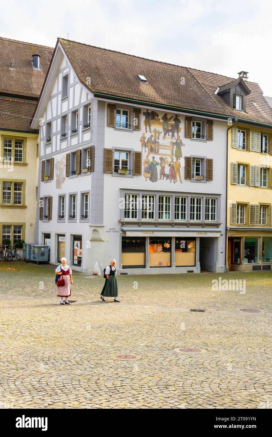 Two women in folkloric clothes on the market square at Old post office square (Alter Postplatz) in Zofingen old town, canton of Aargau, Switzerland. T Stock Photo