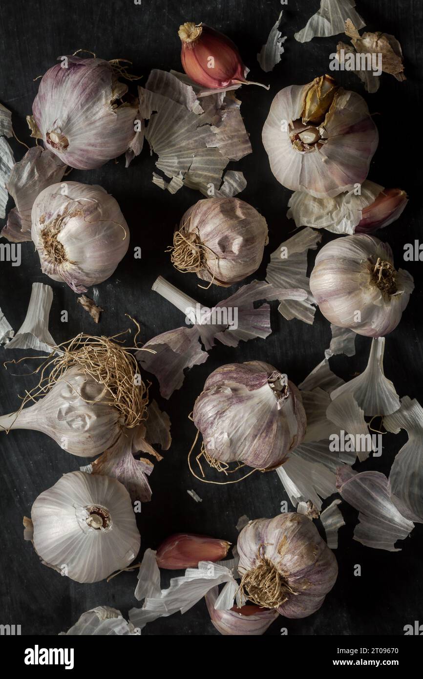 Fresh garlic bulbs and cloves grouped on black background. Flat lay ...