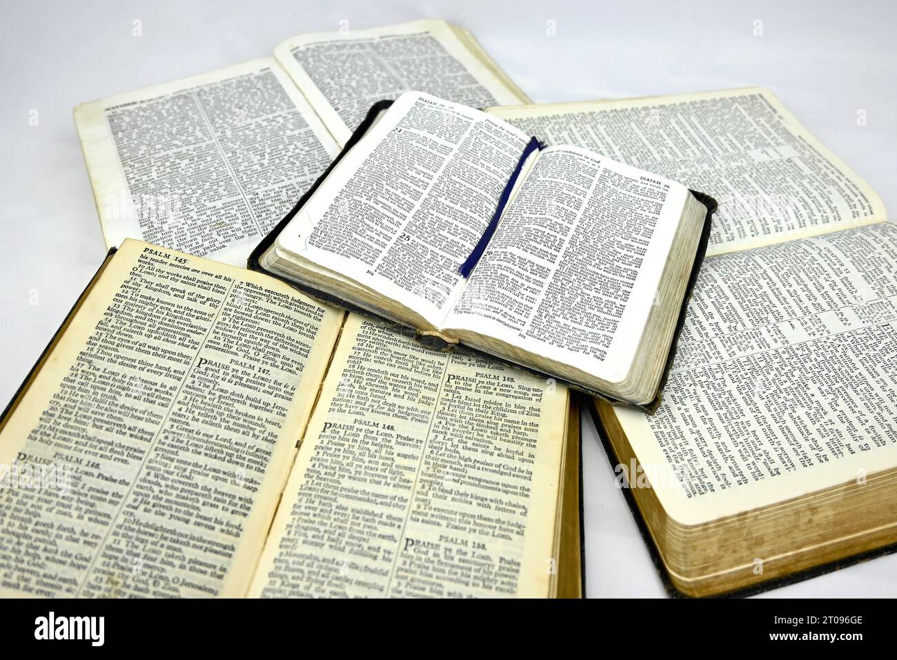 Inside pages of multiple old bibles on a white background Stock Photo
