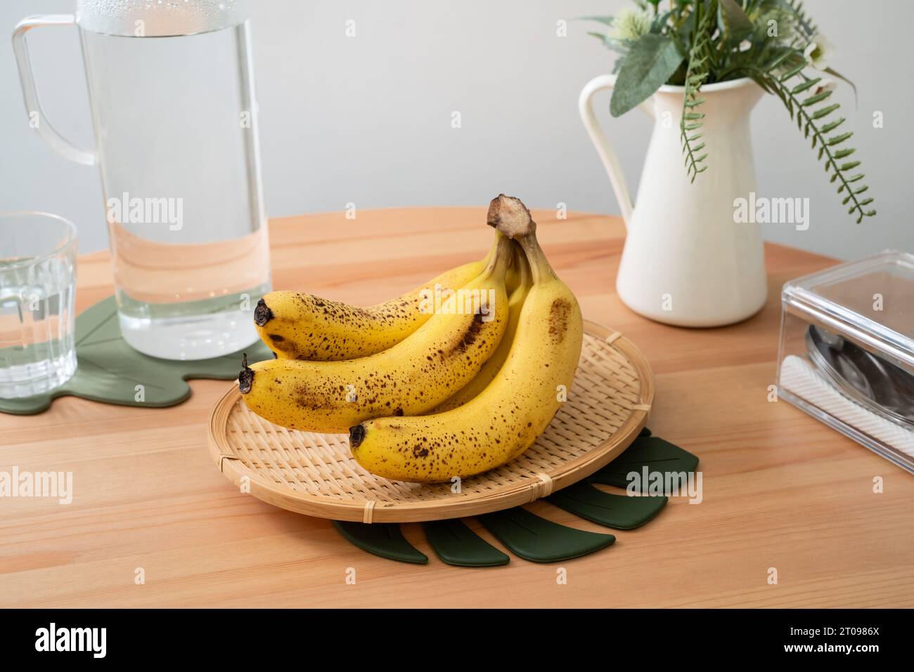 A bunch of fresh banana lie on the dining table in a modern kitchen, healthy life concept. Stock Photo