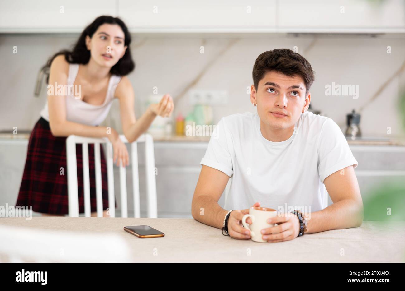 Angry young wife swears at her husband, family quarrel. Stock Photo