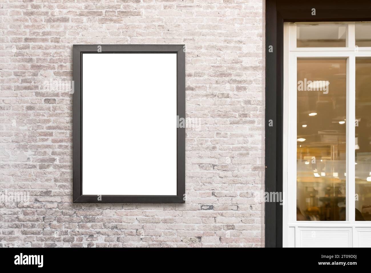 Vertical billboard mounted on a brick wall beside a shop door, offering an isolated surface ideal for design promotion, creating an attractive adverti Stock Photo