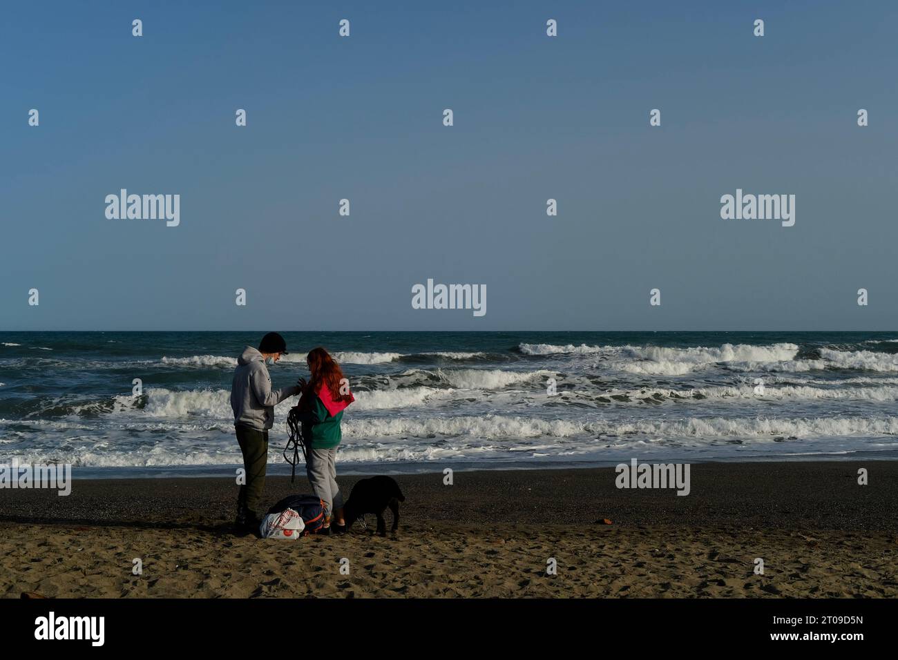 Couple on the beach, winter day with lots of waves Stock Photo