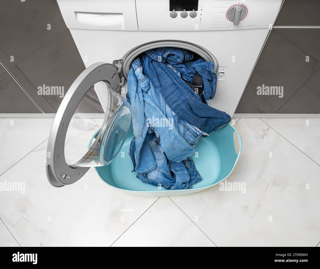 Washing denim items in the washing machine. Stock Photo