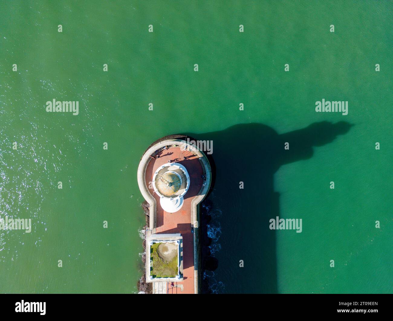 Aerial top down view of old stone lighthouse reflecting shadow on ...