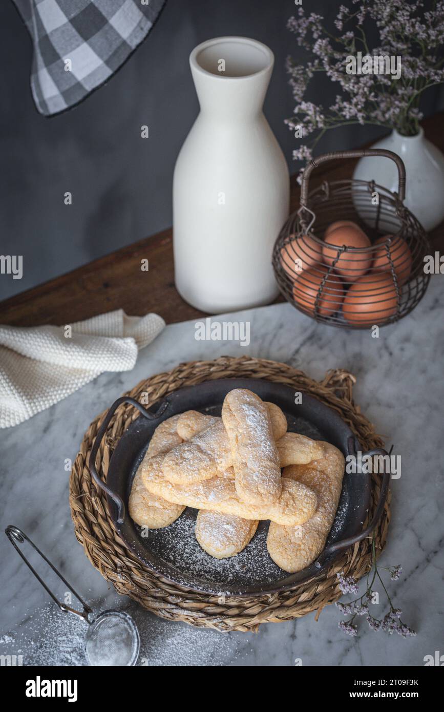 High angle of tray with crunchy ladyfingers finger sponge cake placed on table near eggs and jar