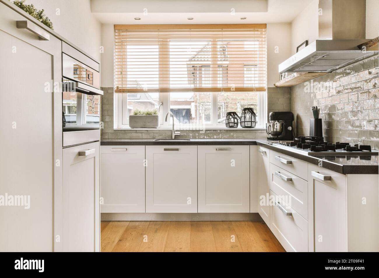 Interior of modern kitchen with white cabinets and built in appliances ...