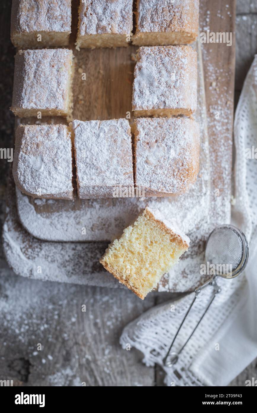 Top view of wooden board with Pasiego cake a typical cake from Catalonia in Spain sprinkled with sugar on rustic wooden table Stock Photo