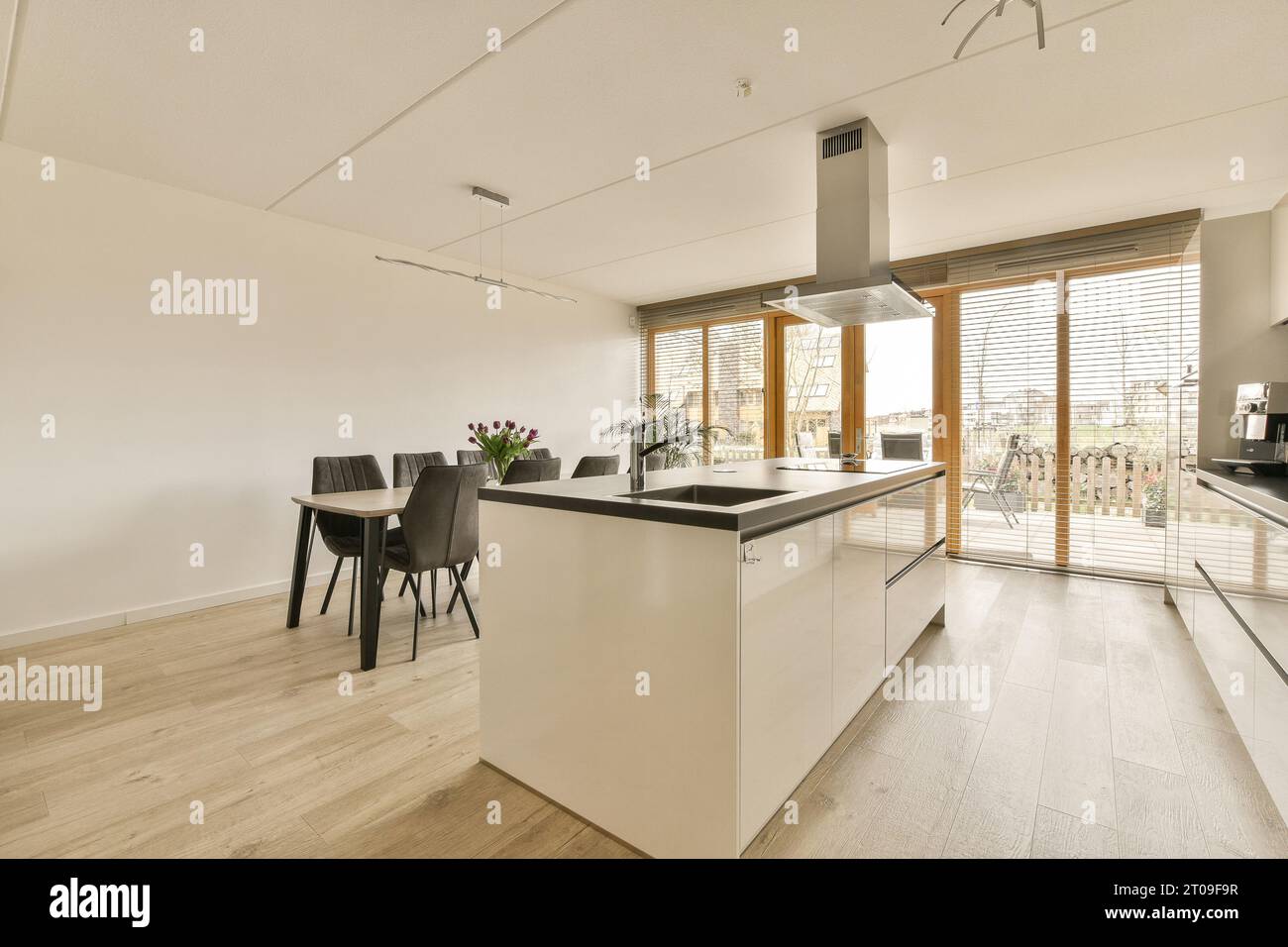 Interior of open plan kitchen with large island and dining table at ...
