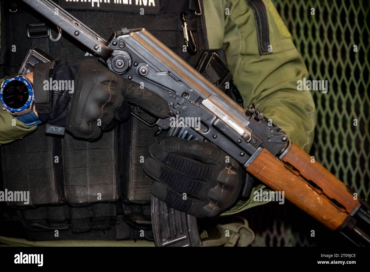 Heavily equipped soldier in camouflage uniform, member of special forcers for anti-terrorisms operations and close combat in war, holding rifle gun Stock Photo