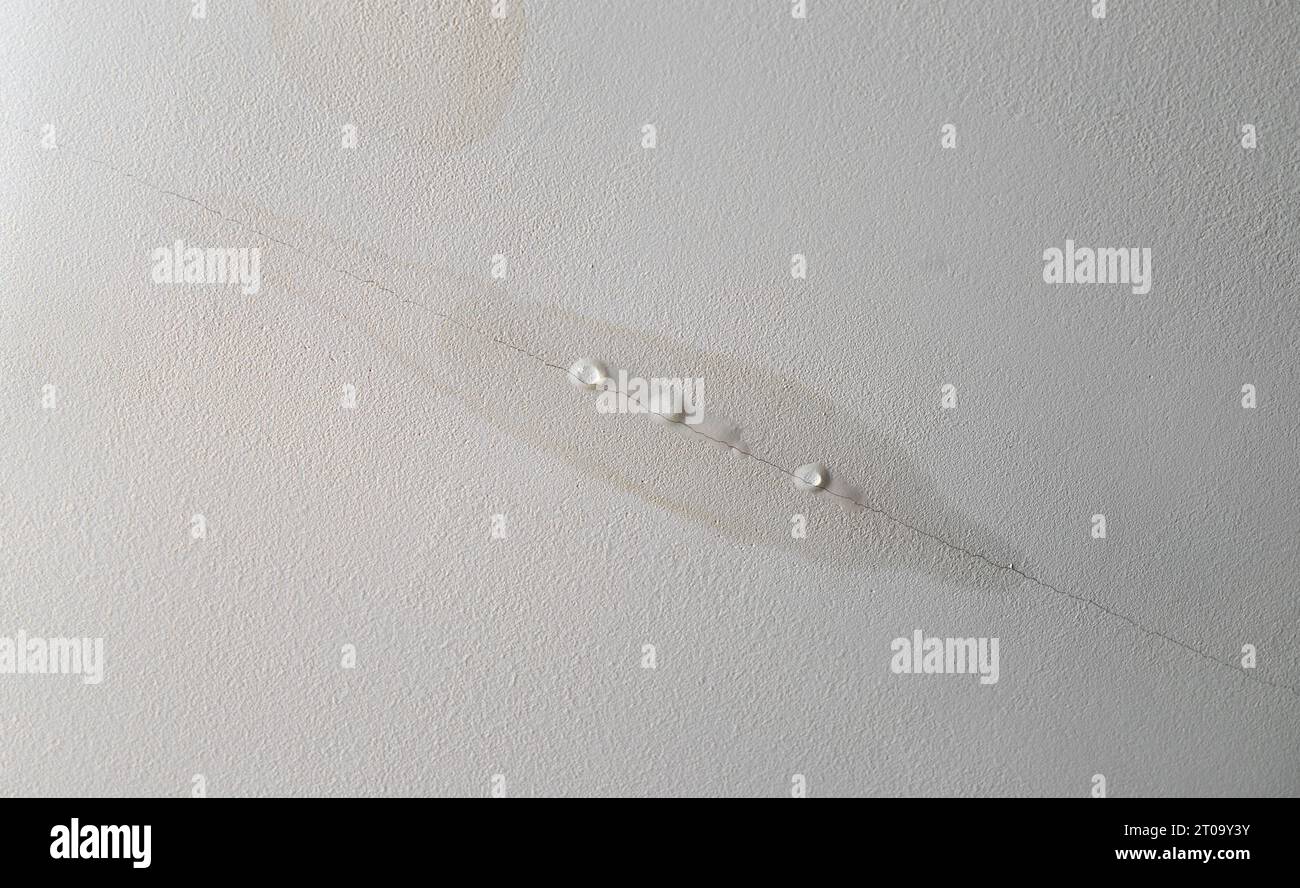 Water is leaking from drywall ceiling in home room, water damage. Water