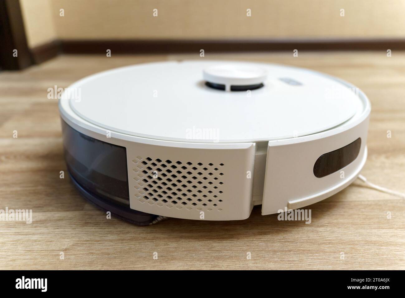 Modern white robotic vacuum cleaner. Self Drive Cleaning Robot. Floor
