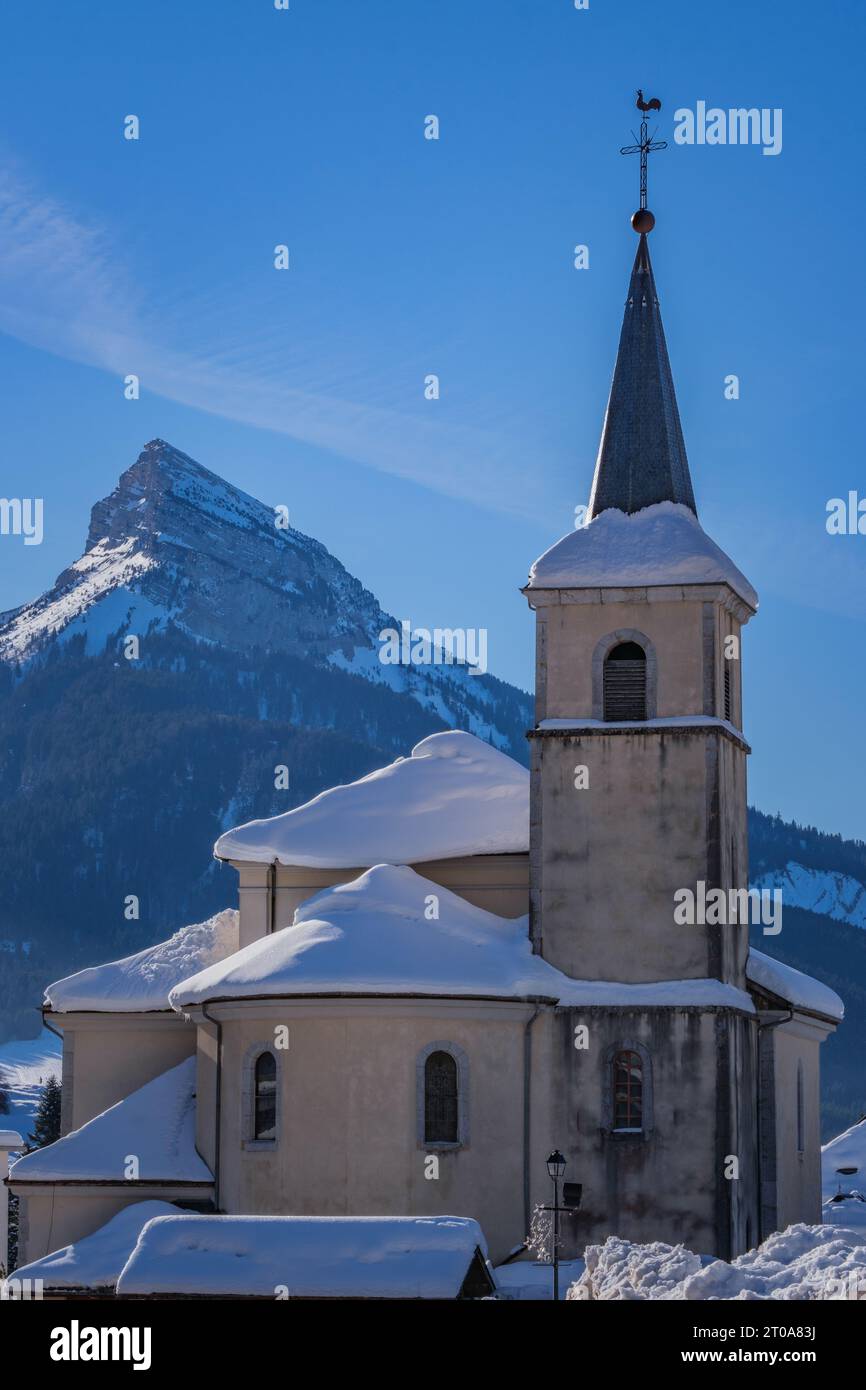 View on the church of Saint Pierre de Chartreuse and the Chamechaude peak covered in snow in the French Alps Stock Photo
