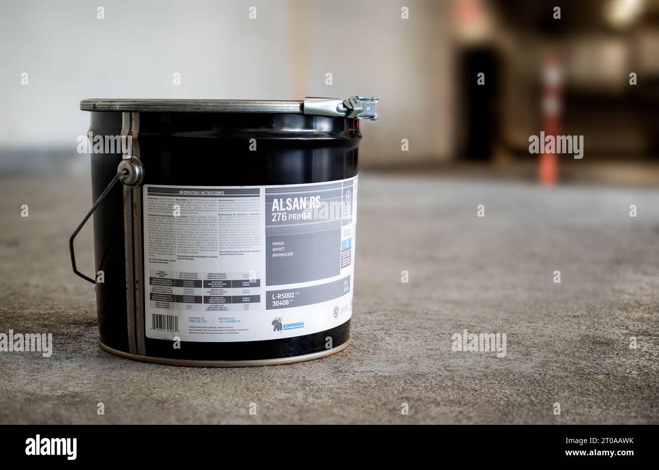 Large container of primer liquid on parking garage floor. Polymethyl ...