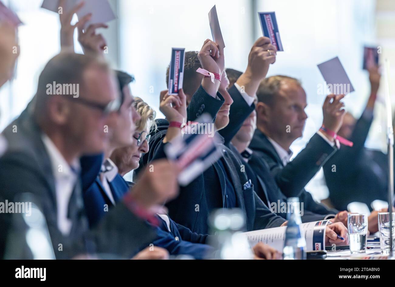 05 October 2023, SchleswigHolstein, Neumünster Delegates raise their