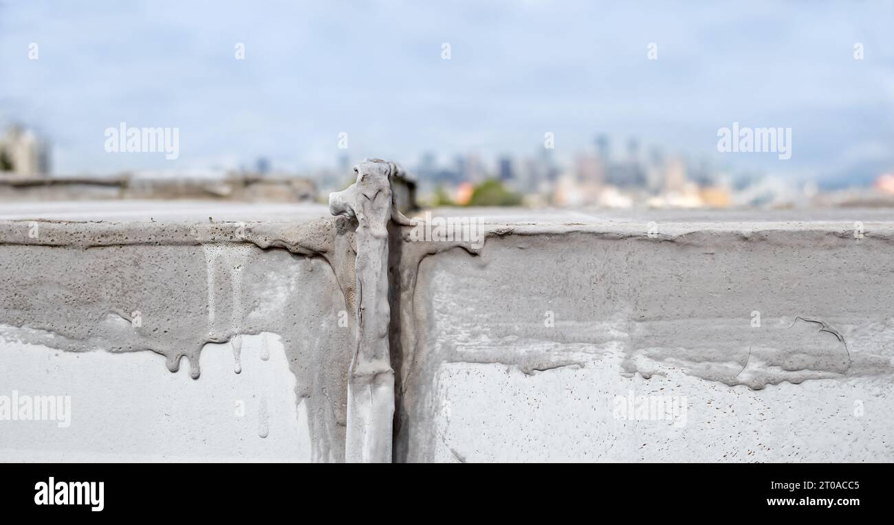 Close up hvac unit waterproofing repair on flat roof with downtown