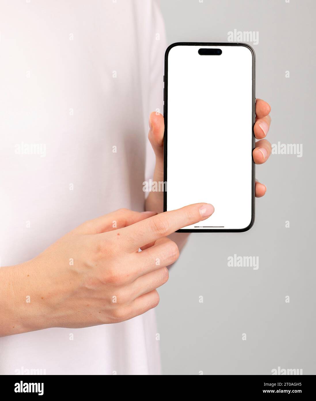 Berlin, Germany September 16 2023 Hand indicating at white mobile phone screen mockup, smartphone mock up, tapping with index finger Stock Photo