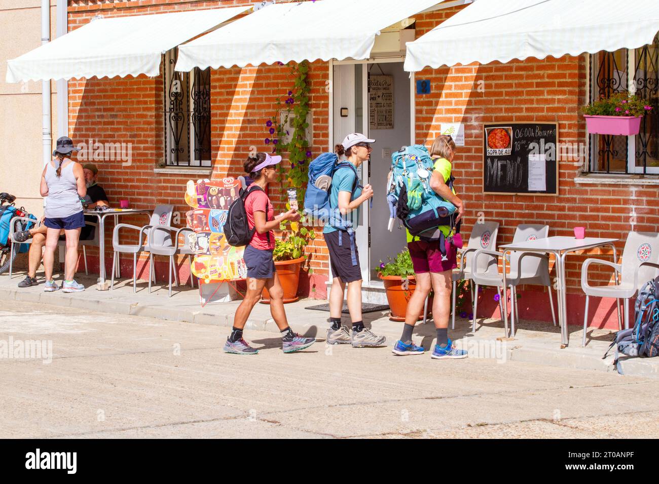 Pilgrims in the Spanish village of  Calzadilla  de la Cueza stopped at an albergue for lunch while walking the Camino de Santiago the way of St James Stock Photo