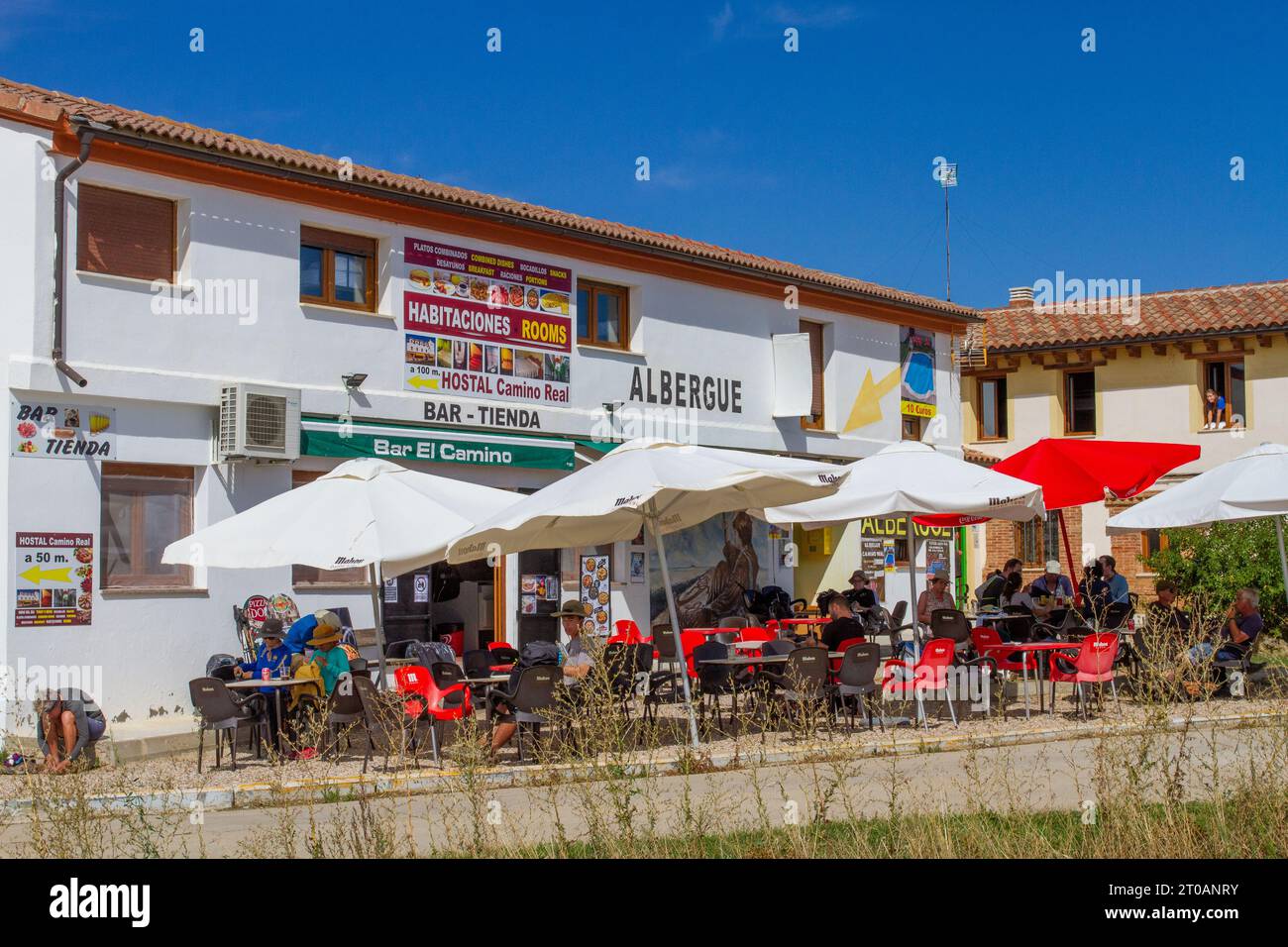 Pilgrims in the Spanish village of  Calzadilla  de la Cueza stopped at an albergue for lunch while walking the Camino de Santiago the way of St James Stock Photo