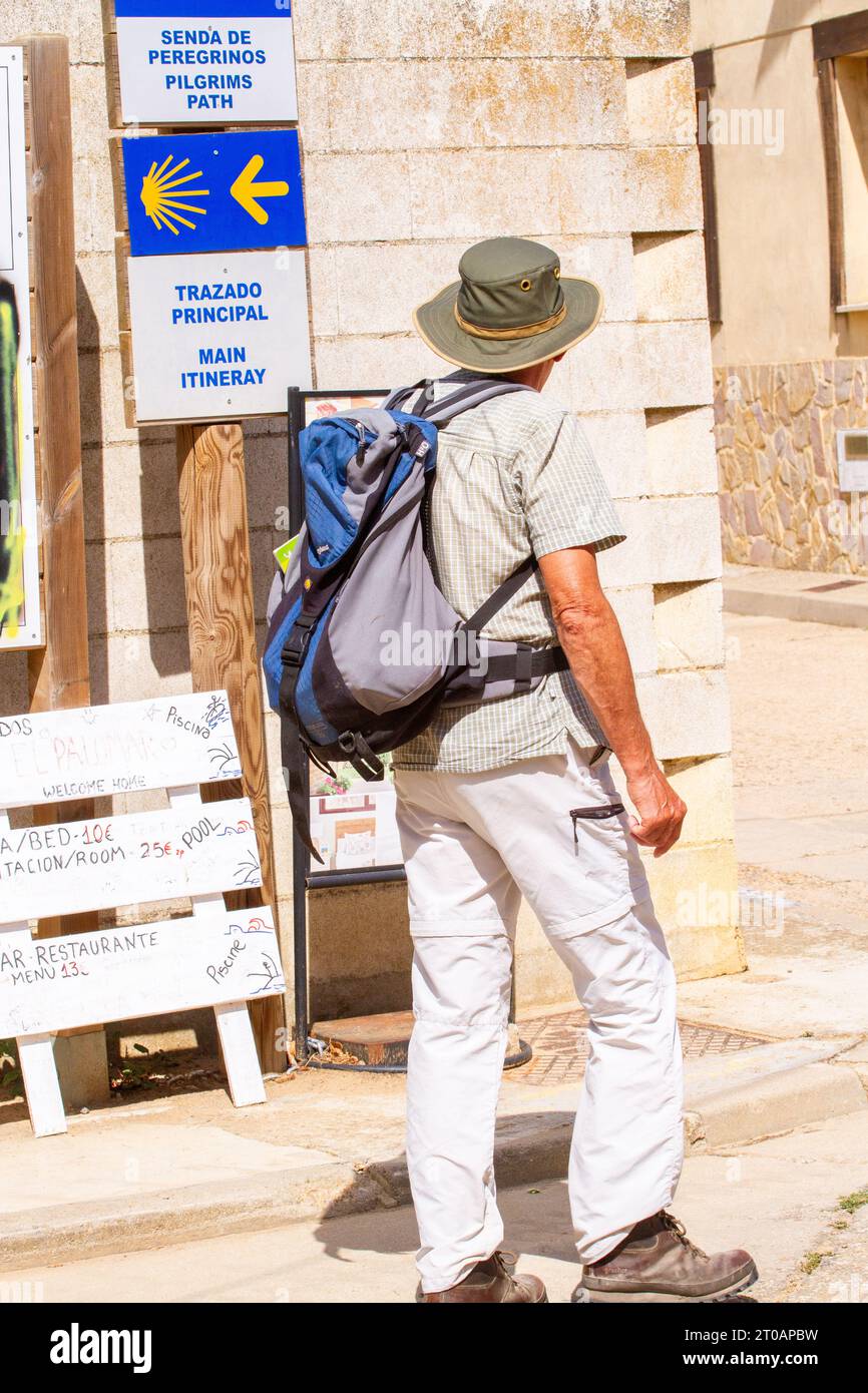 Pilgrim walking the Camino de Santiago the way of St James through the Spanish village of  Ledigos Spain Stock Photo