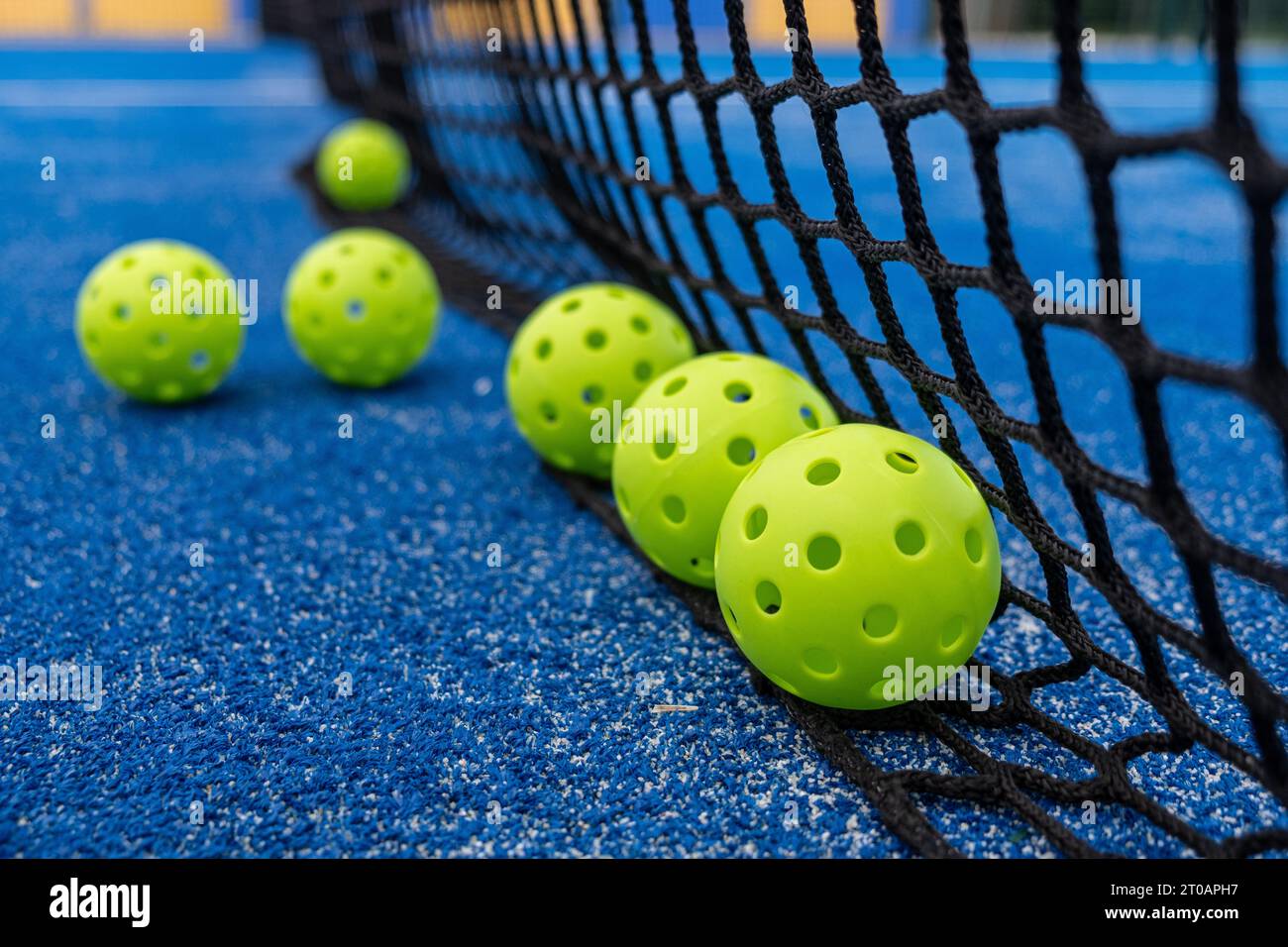 Green pickleball balls at the base of the net, new racket sport Stock ...