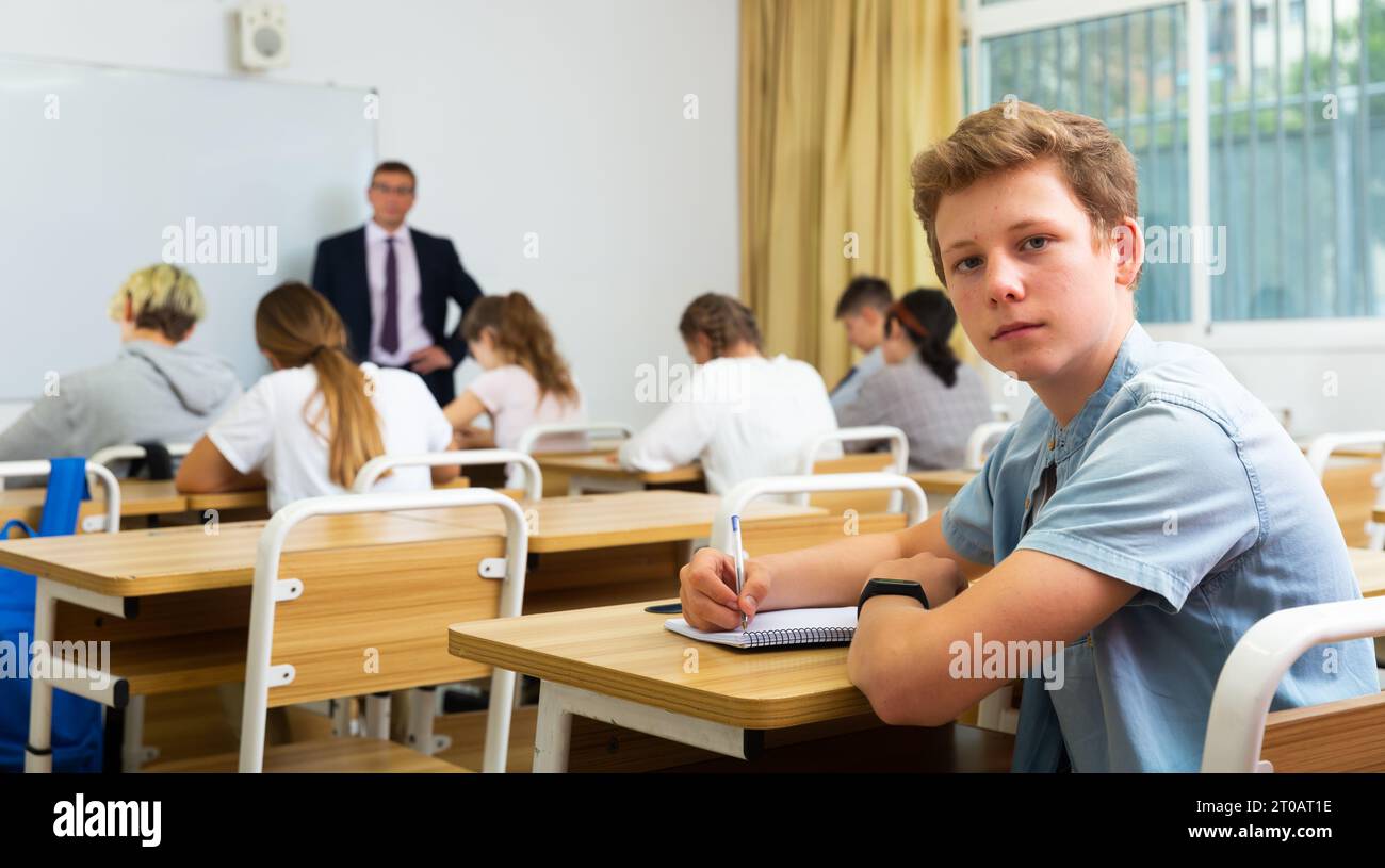 Portrait of teenager who is posing at the desk in class Stock Photo - Alamy