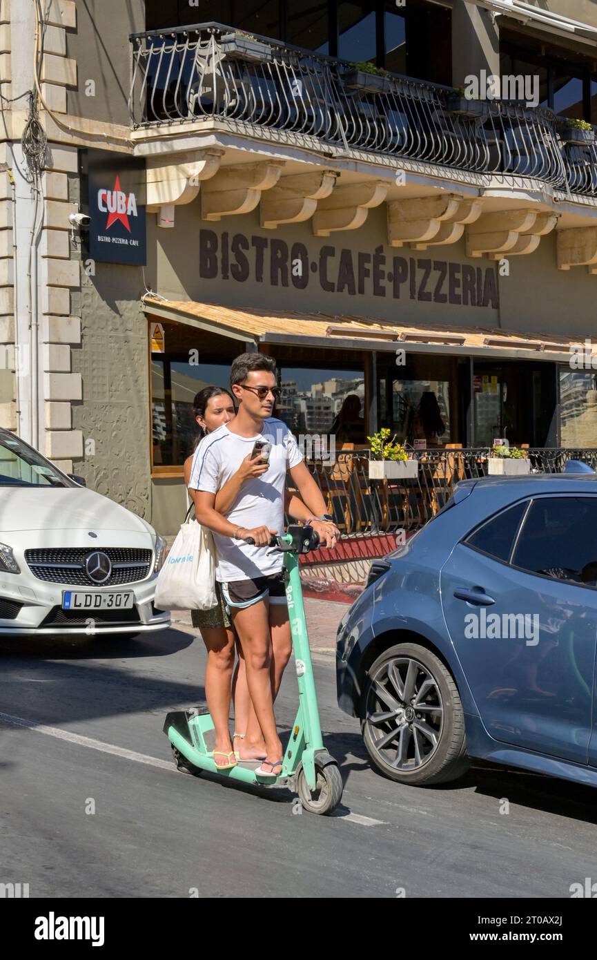 St Julians, Malta 3 August 2023 Two people riding downhill among
