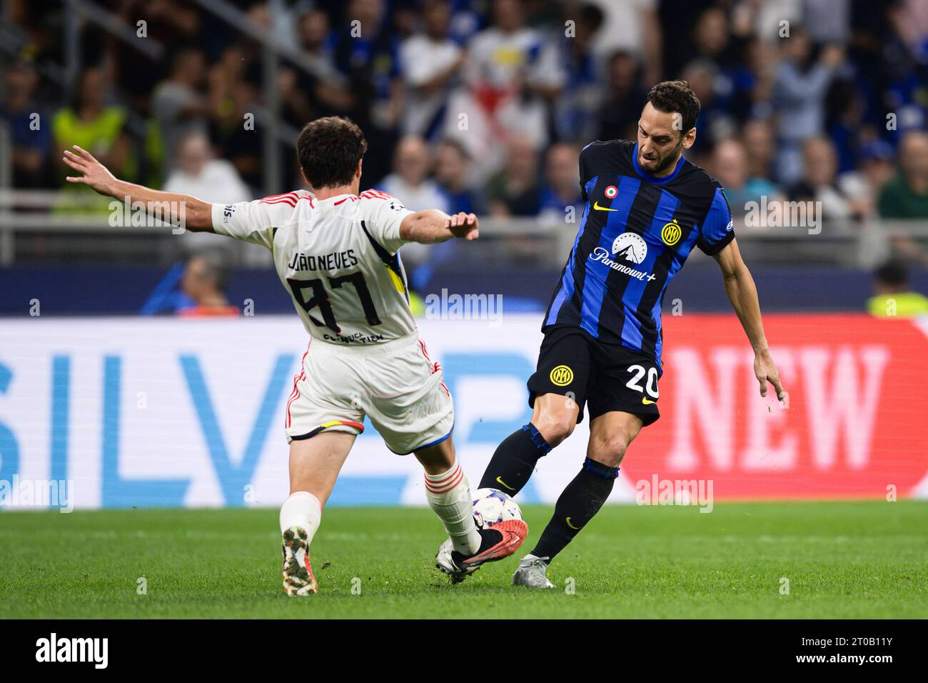 Hakan Calhanoglu of FC Internazionale competes for the ball with Joao Neves of SL Benfica during the UEFA Champions League football match between FC Internazionale and SL Benfica. Stock Photo