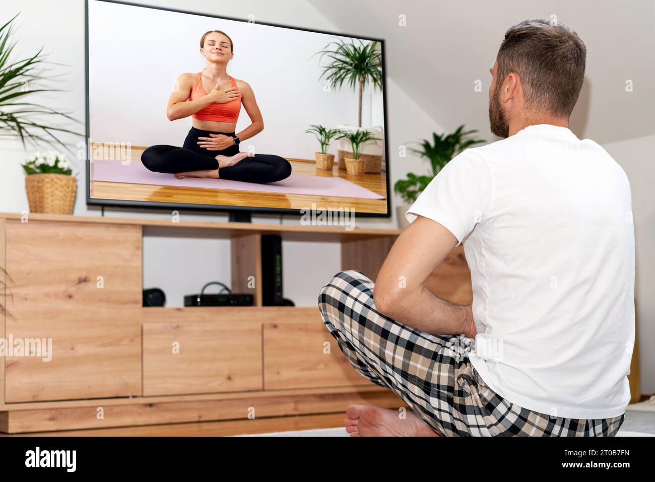 Online yoga video training. People doing yoga at home. Online client. Sport and wellness tv channel. Stock Photo